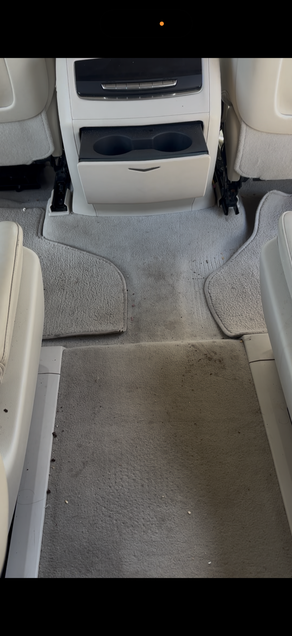 Rear cabin carpet with visible dirt and marks before cleaning