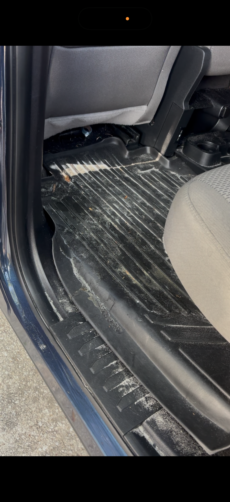 Jeep rear floor mat and door sill covered in dirt before detailing