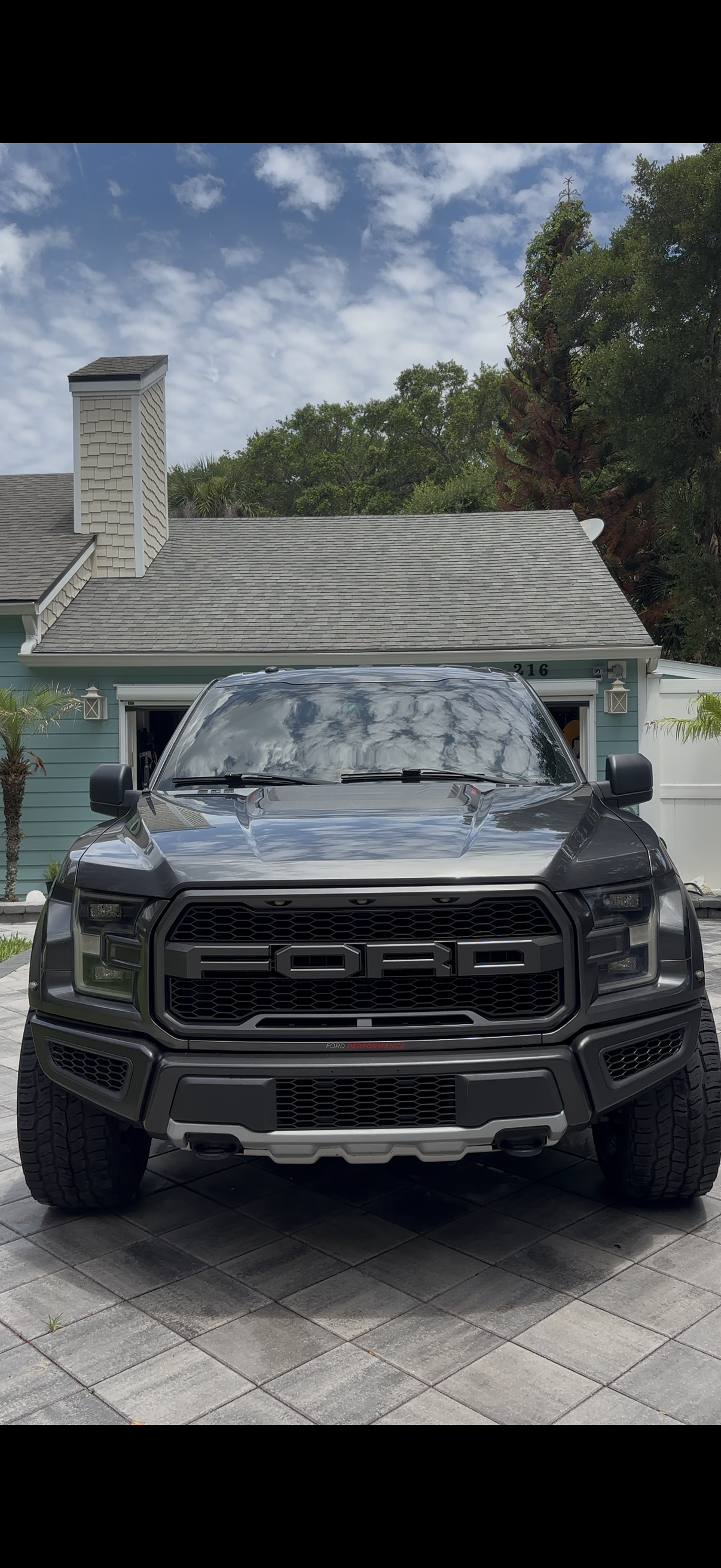 Clean gray Ford truck viewed from the front, with reflective paint and detailed grille