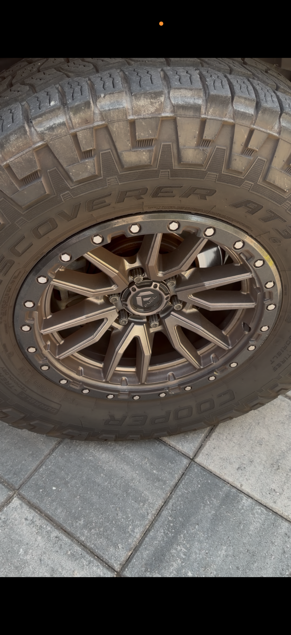 Off-road wheel and tire with dirt and dull surfaces before cleaning